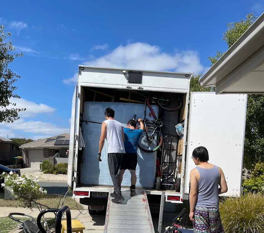 Truckmen two-person crew loading furniture and bikes into the truck on a Canberra job