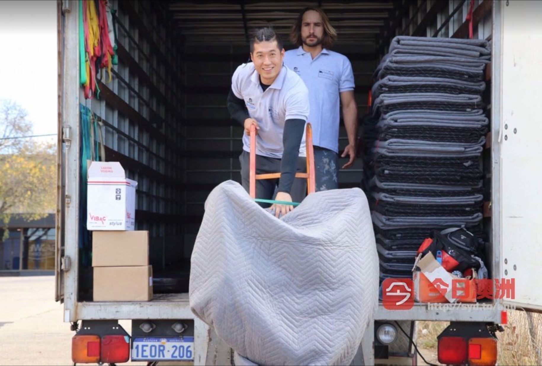 Truckmen removalists loading a chair into a truck