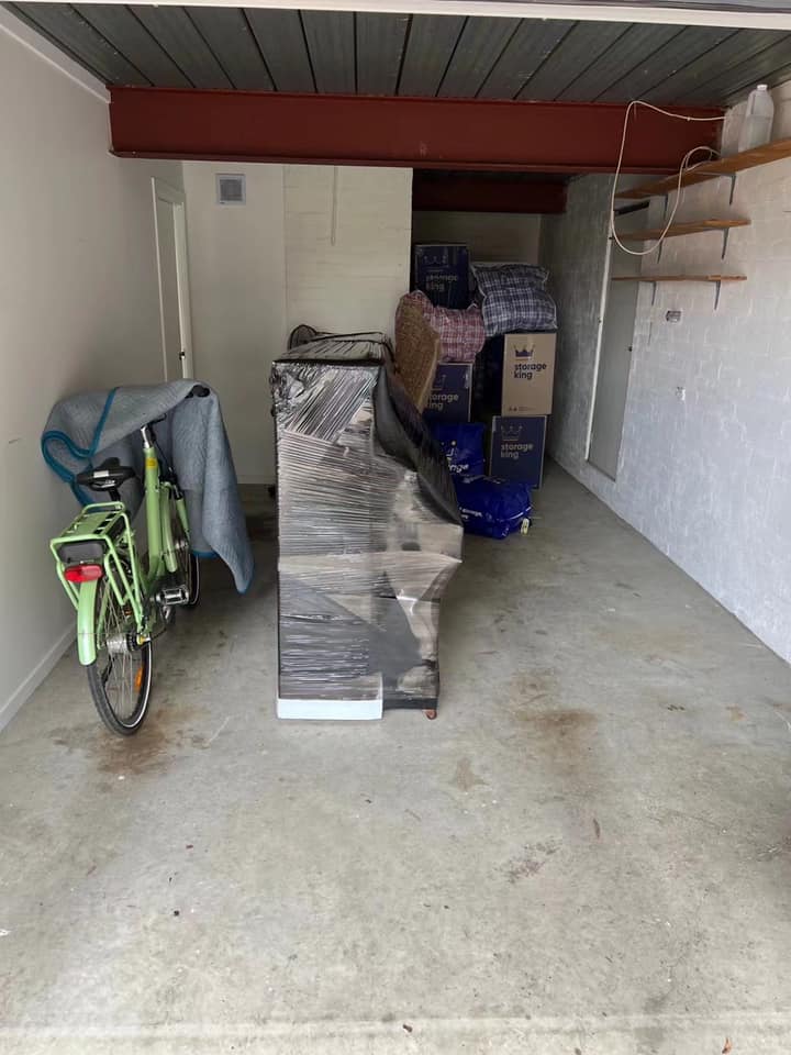 Truckmen removalists carefully loading wrapped furniture into a moving truck